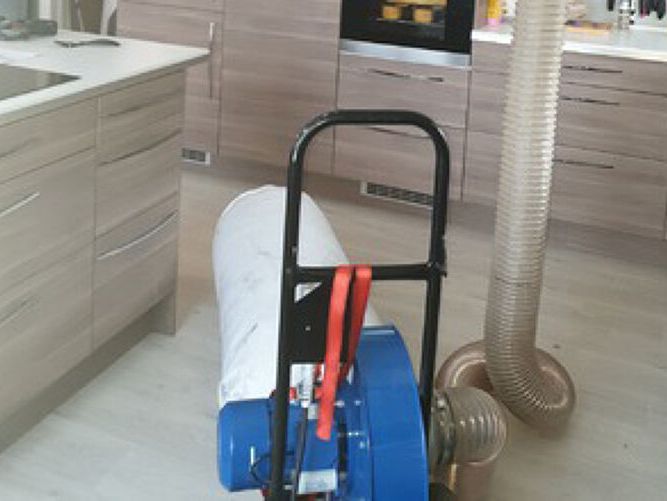 Maskin som suger ut støv av ventilasjonsnlaegg